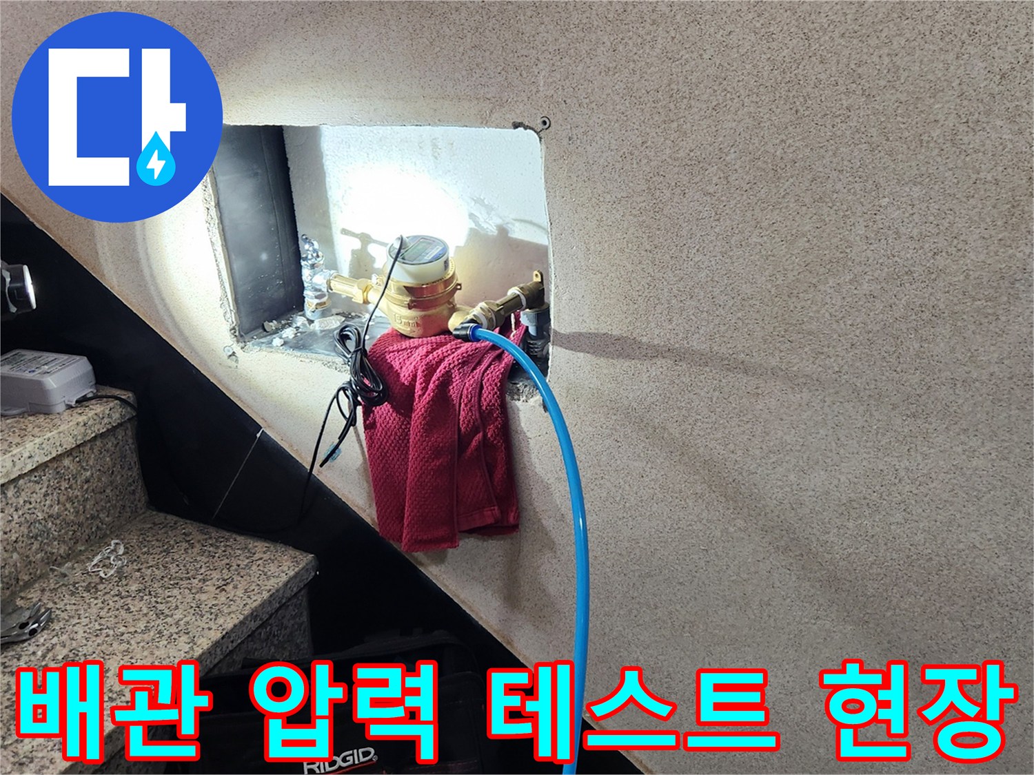 벽면 타공 부위에서 진행 중인 수도 배관 공압 검사