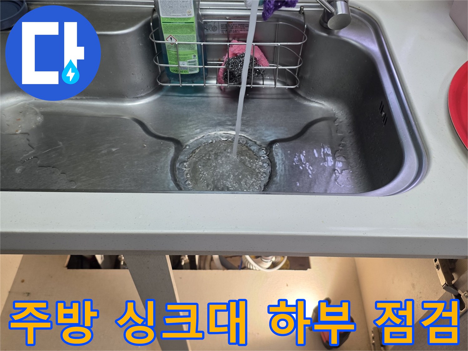 싱크대 배수구와 정수기 호스가 연결된 내부 구조물 사진