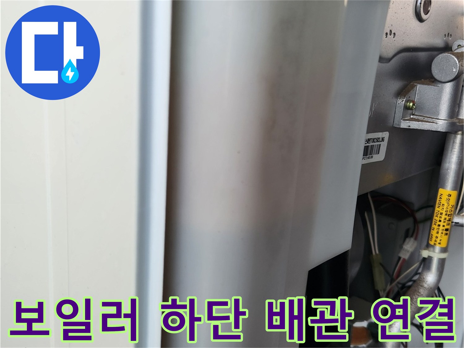 보일러 내부의 금속 관과 노란색 라벨이 붙은 부품 사진입니다.