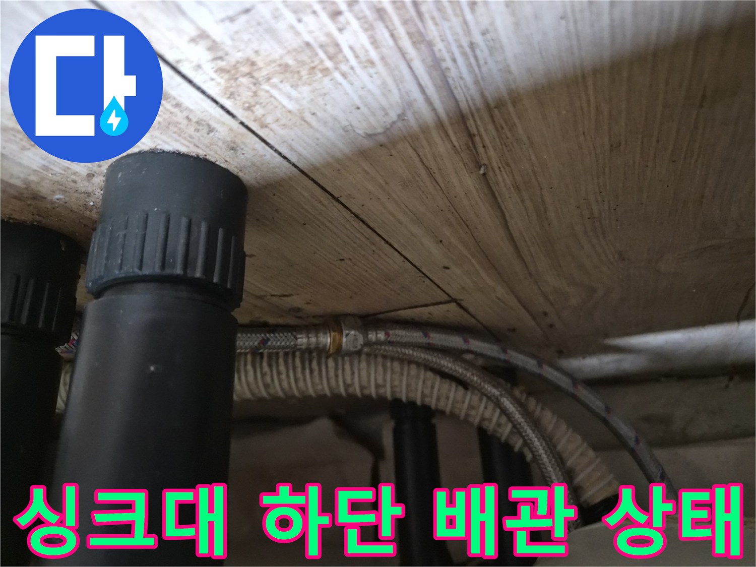 싱크대 하단-노후된 온수 호스 및 검은색 배관 모습