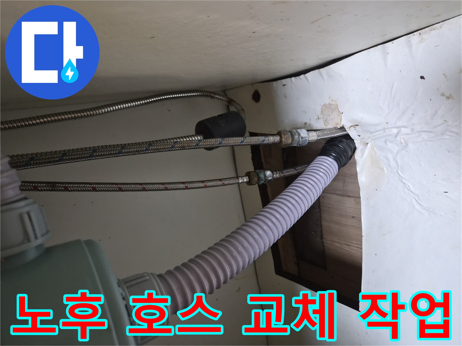 싱크대 하부의 금속 고압 호스와 흰색 배수 호스 연결 상태