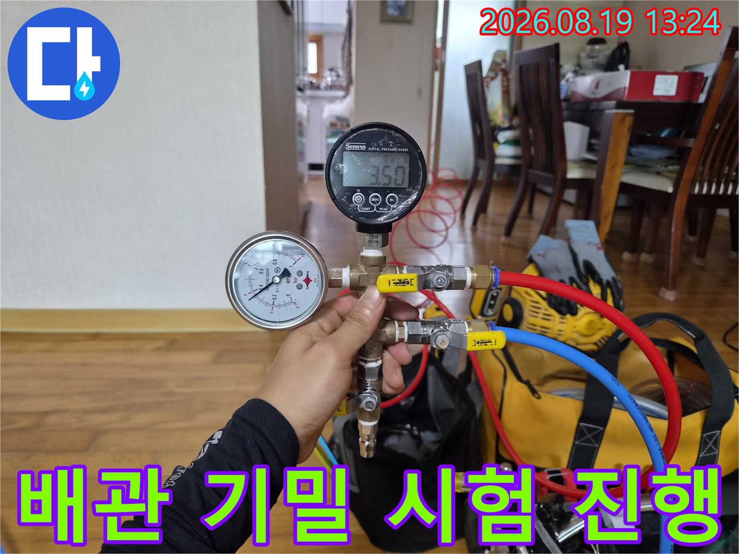 디지털 압력계를 사용하여 배관의 압력을 정밀하게 측정하는 장면입니다.