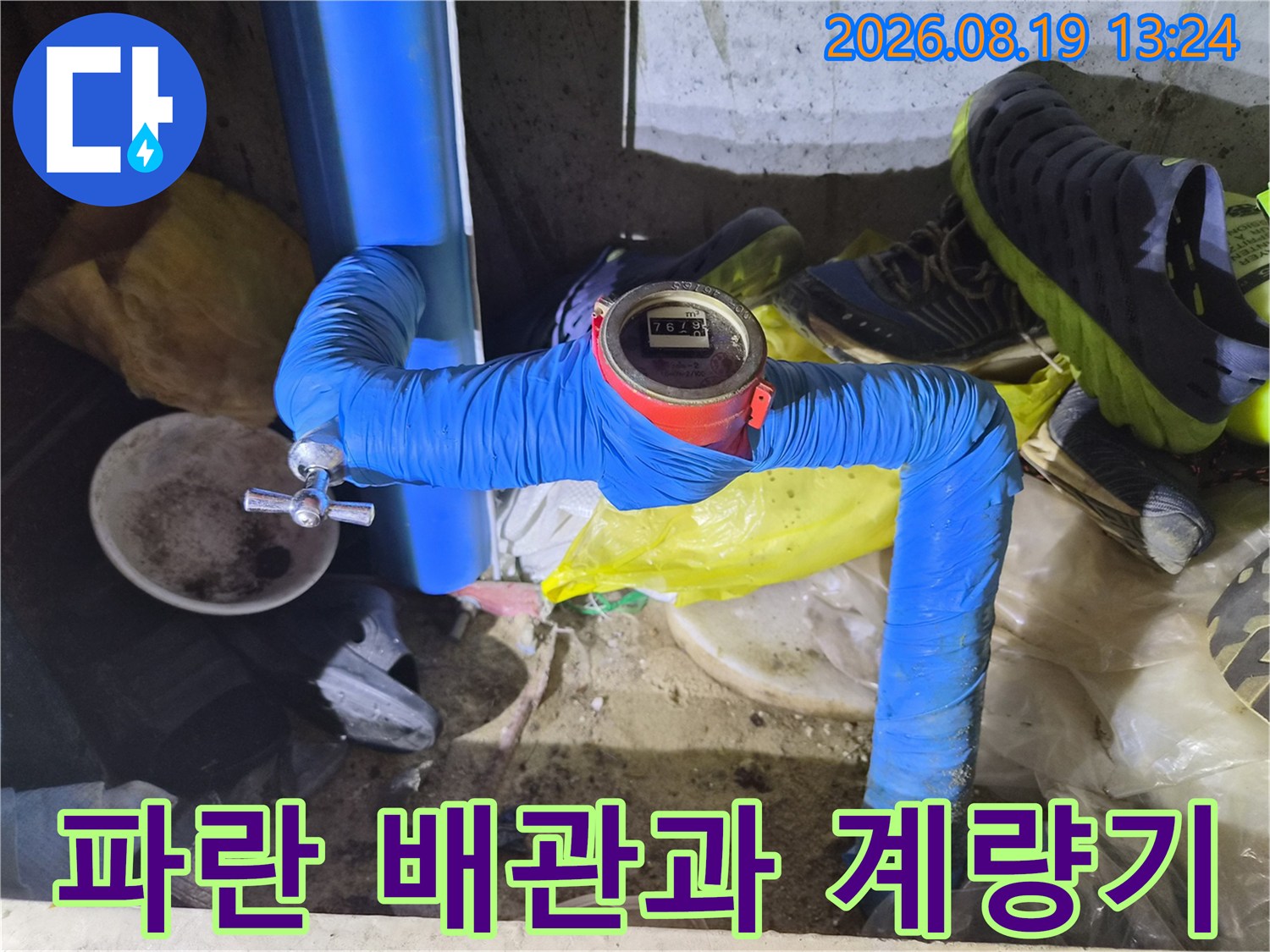 파란색 보온재로 감싸진 배관에 설치된 디지털 수도 계량기 모습입니다.