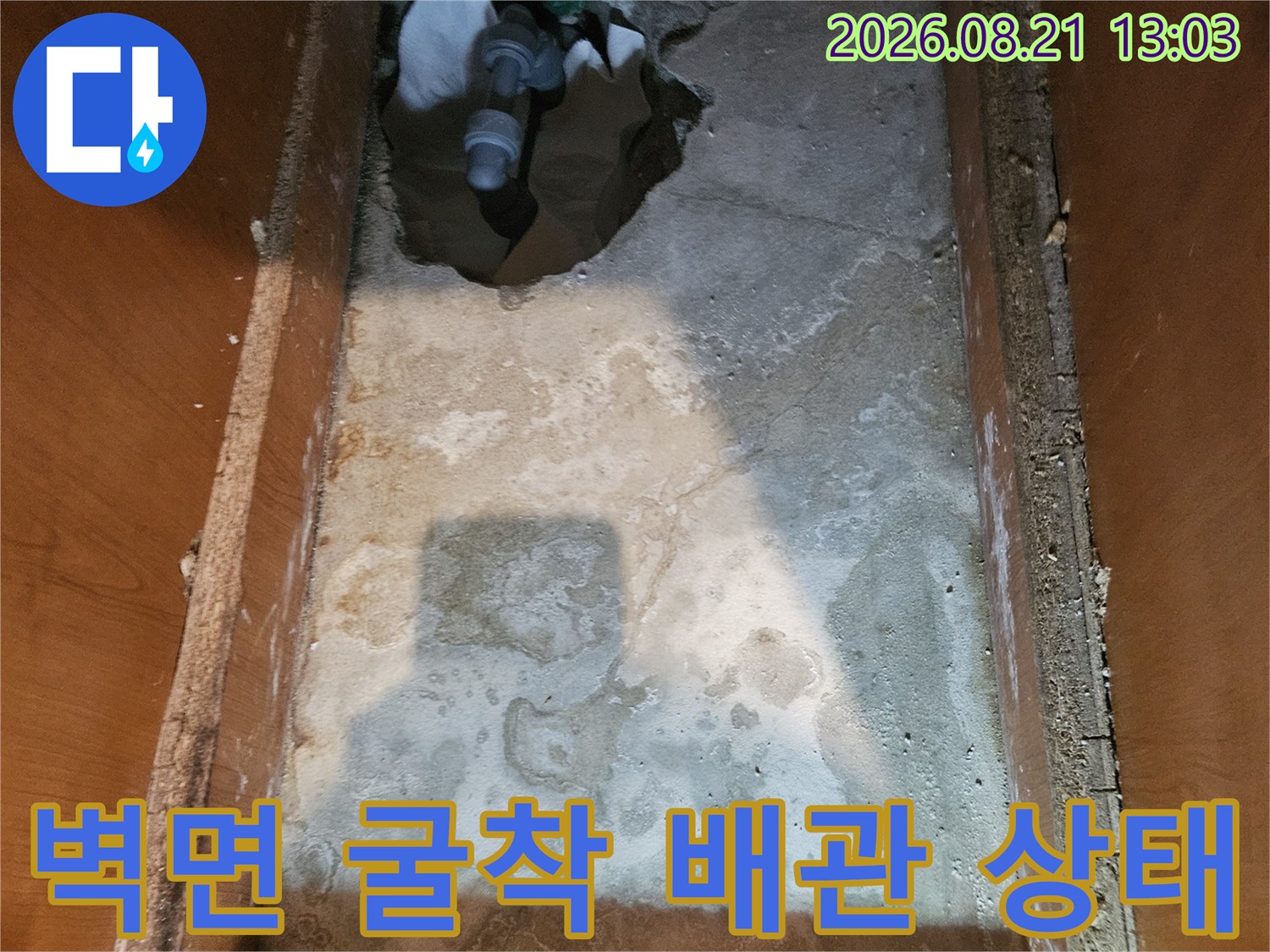 콘크리트 벽면을 파내어 드러난 노출된 PVC 배기 배관과 습한 벽체