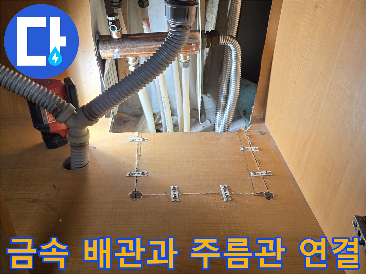 싱크대 하부의 금속 관과 은색 주름관이 만나는 지점
