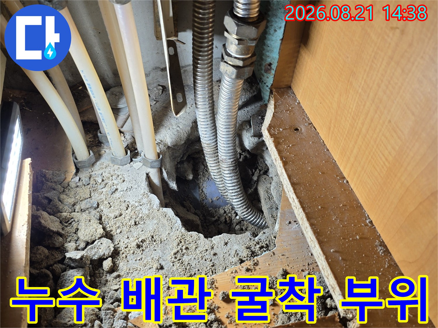싱크대 하부장 아래 파헤쳐진 바닥과 노출된 배관 구조물