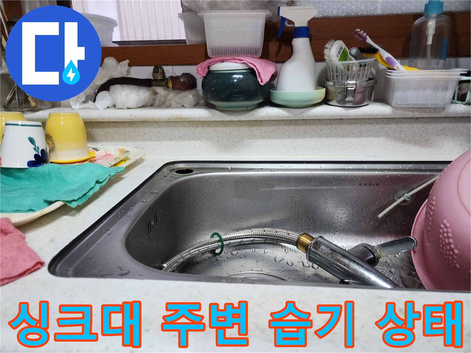 주방 싱크대 수전과 배수구 주변의 맺힌 물기를 보여주는 사진입니다.