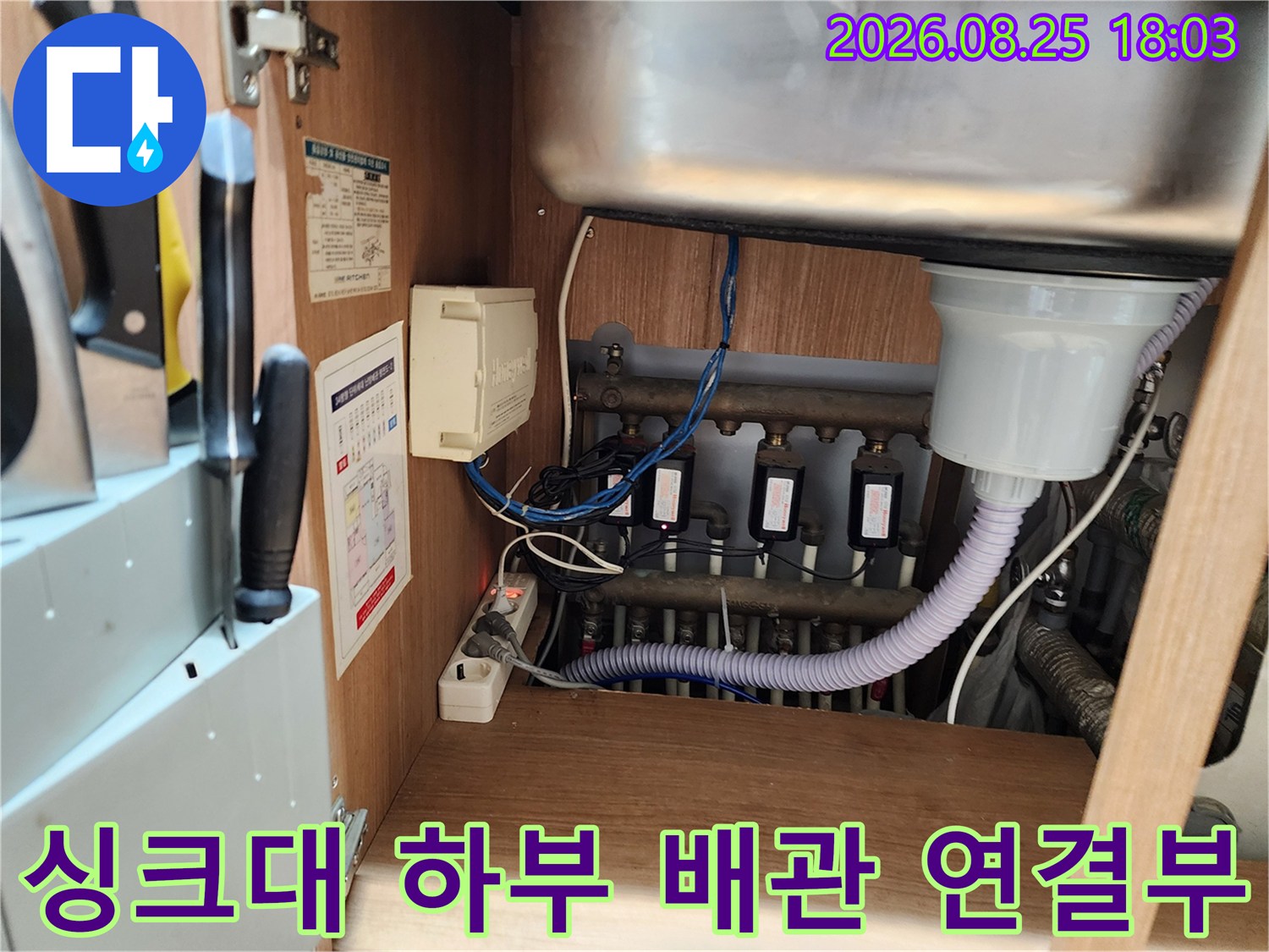 싱크대 밑에 설치된 여러 갈래의 배수 호스와 관로들