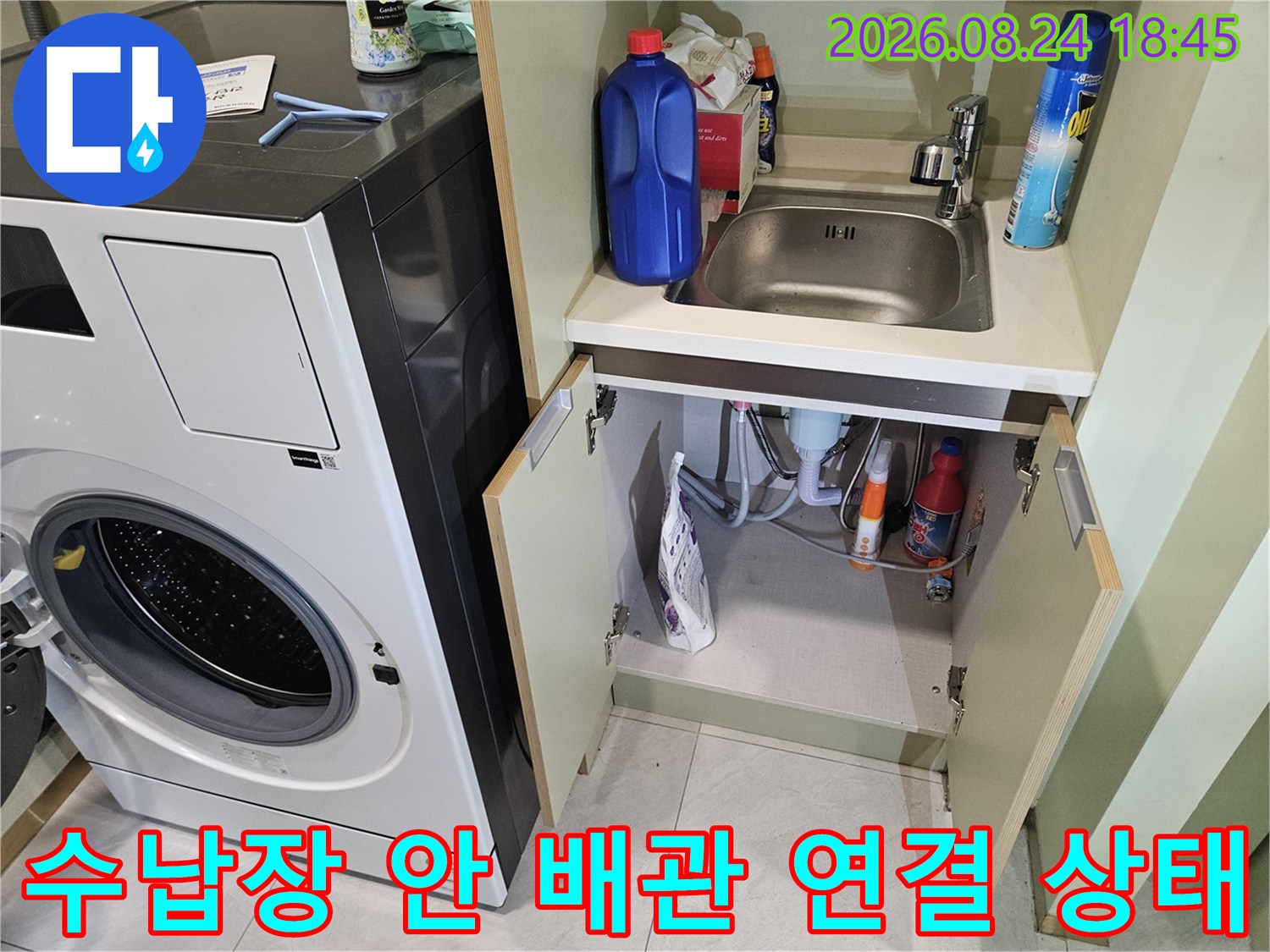 세탁기 주변 수납함 내부에 위치한 배관과 세제 용기들