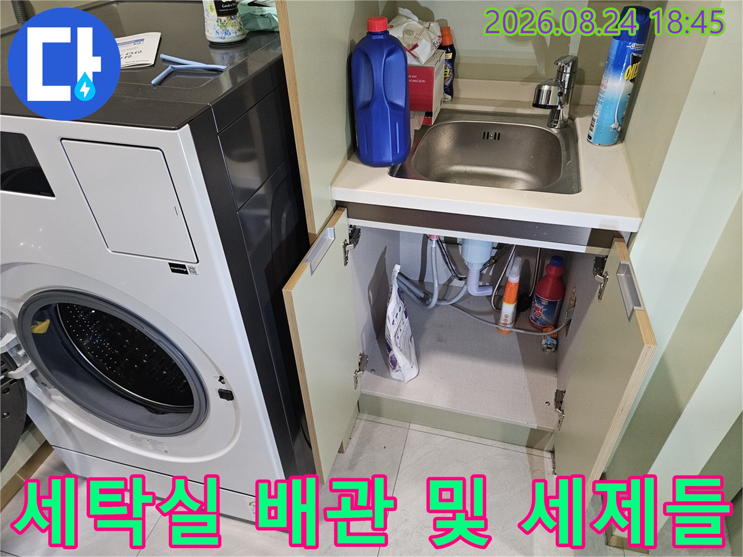 하부장 내부의 배관과 놓여있는 세제 용기들