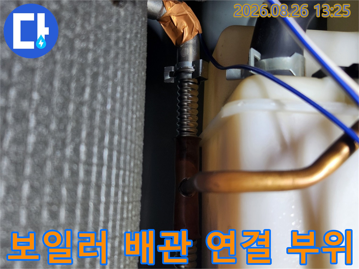 보일러실 내부의 구리 배관과 연결된 배관들의 근접 사진