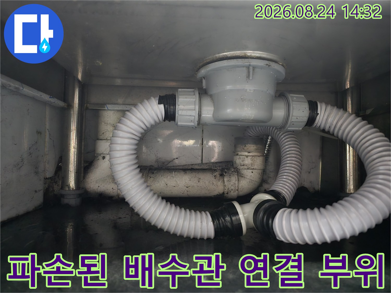 싱크대 하부의 굴곡진 주름관과 배수통 연결 부위를 근접 촬영했습니다.