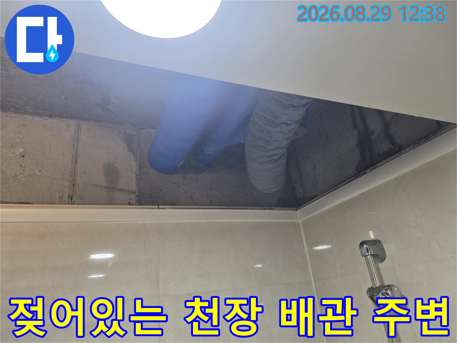 파란색 배관과 은색 자재가 연결된 화장실 천장 내부 모습