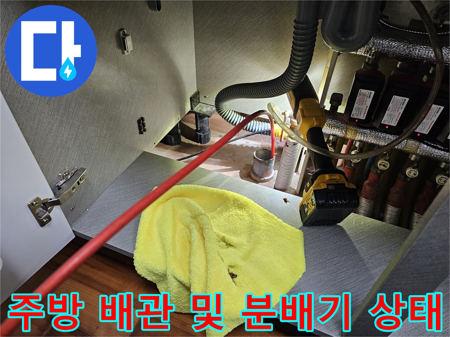 싱크대 하단 공간의 배관 밸브와 전동 드릴 장비가 놓여있는 현장