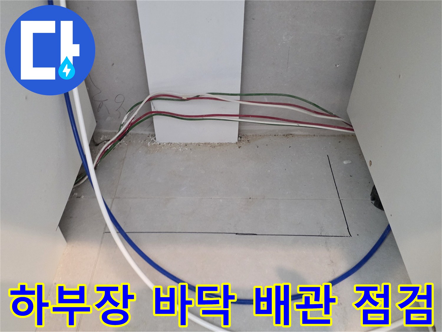 싱크대 하부 공간의 노출된 배관과 전선들의 모습