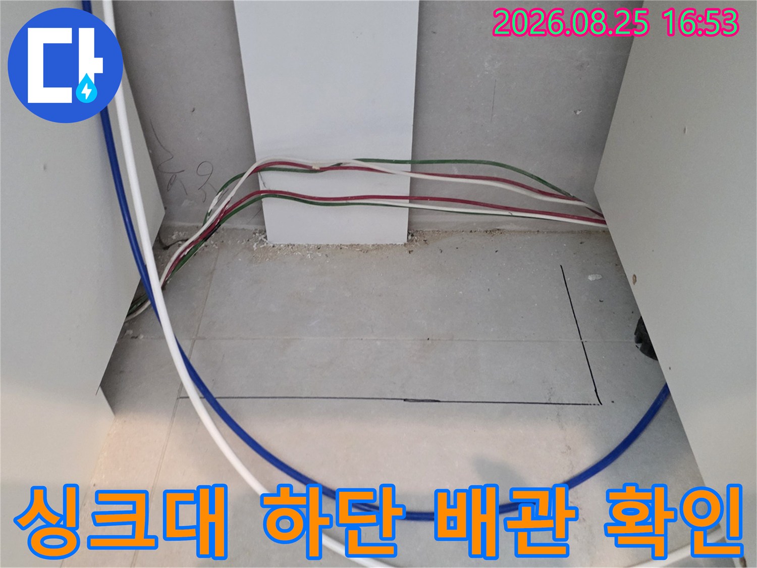 싱크대 하부장 내부-노출된 여러 가닥의 배수 호스