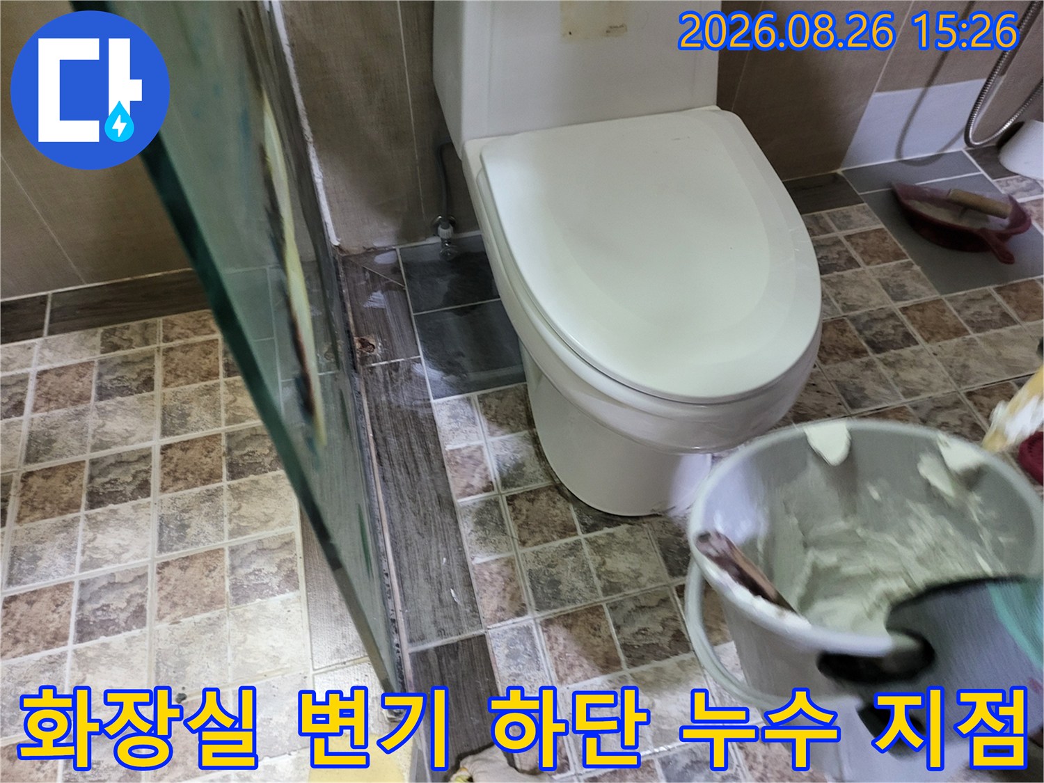 변기 주변 타일의 물샘 흔적과 공사용 반죽 준비