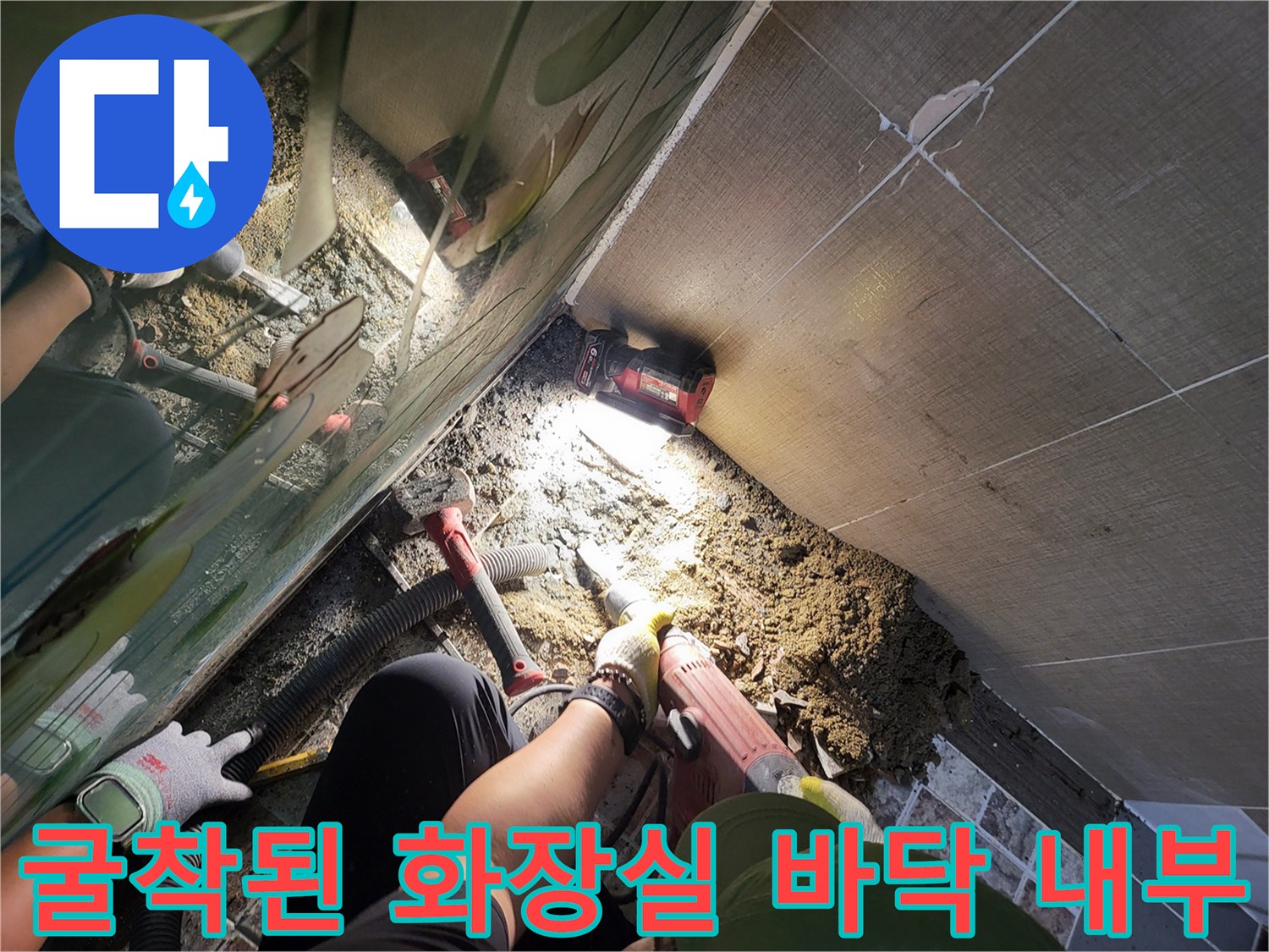 타일 제거 후 드러난 배관 주변의 흙과 작업 도구들