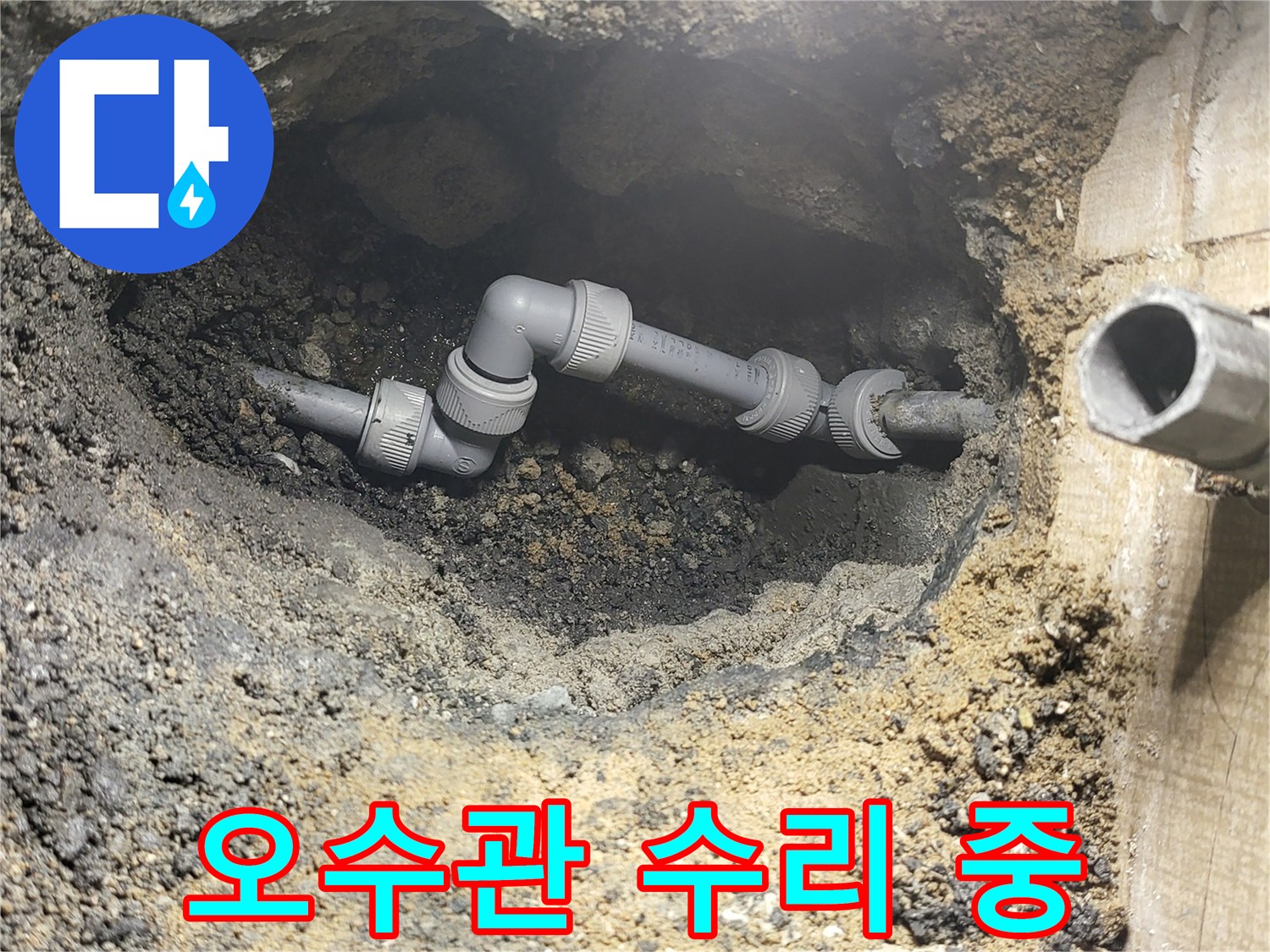 흙더미 사이로 드러난 수리 완료된 오수 배관 연결부