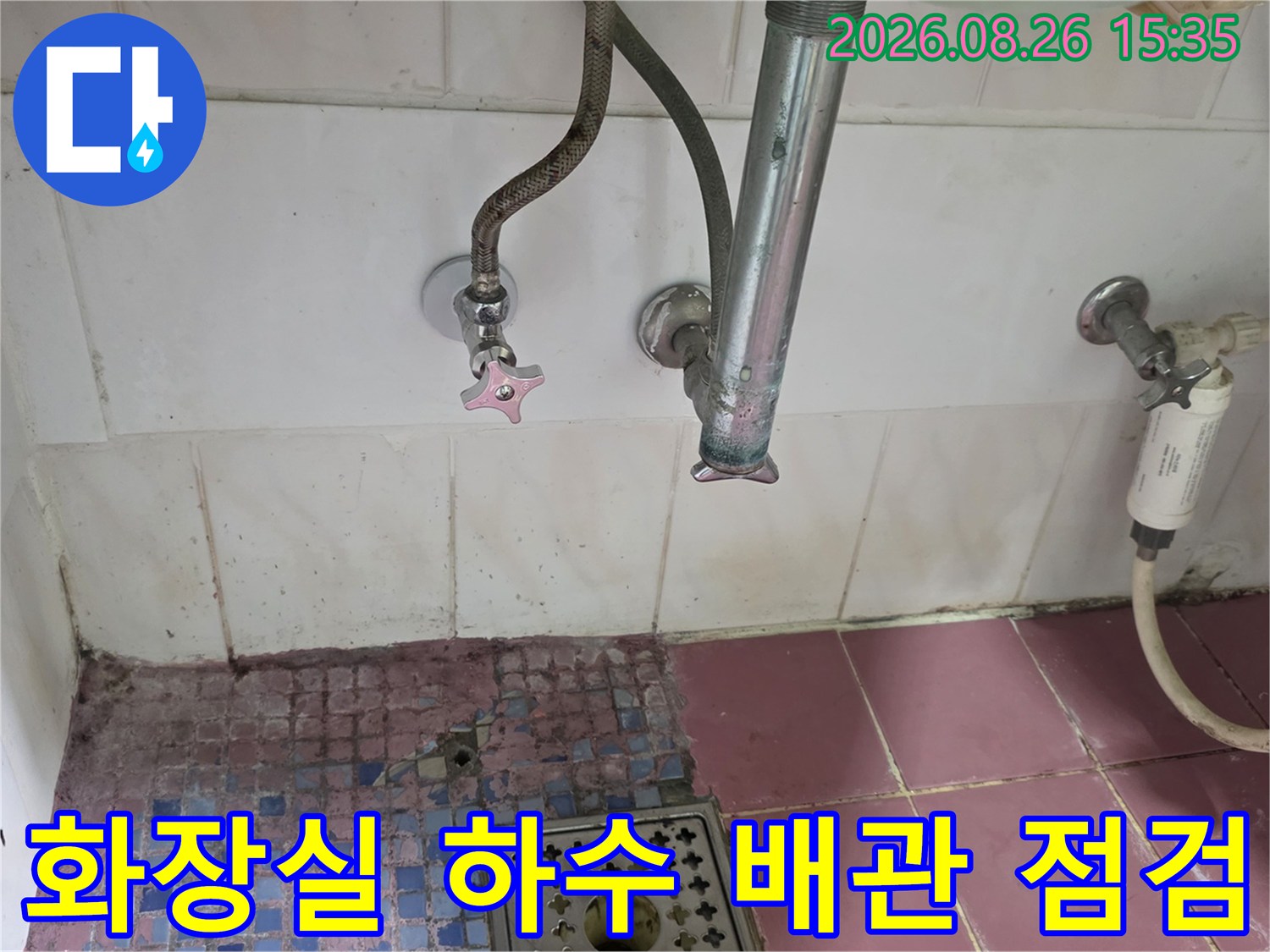 하수구 주변의 수도 밸브와 배관을 촬영한 사진입니다.