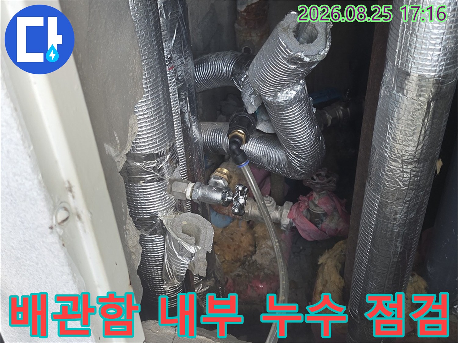 보온재로 감싸진 배관과 밸브 부속이 복잡하게 연결된 배관함 모습입니다.