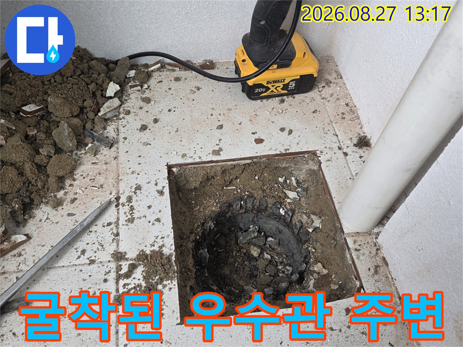 우수관 주변 방수층 결함을 확인하기 위해 타일을 제거한 현장 사진입니다.