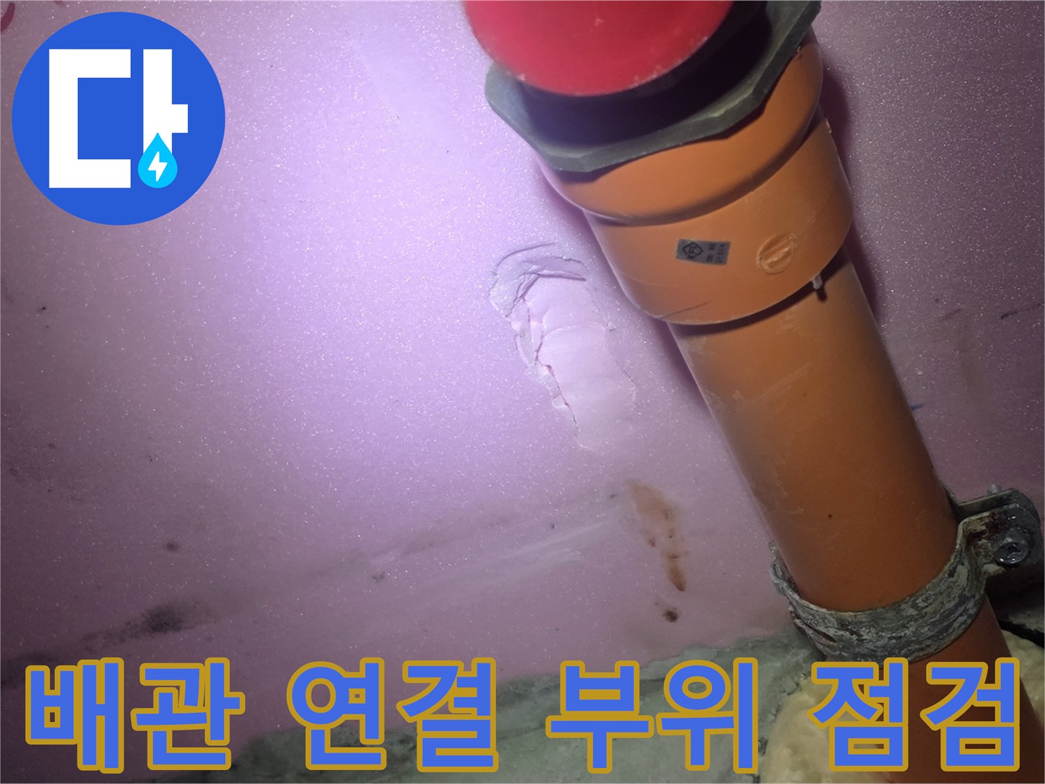 욕실 천장 내부의 주황색 배관과 연결 부위 상태를 근접 촬영한 사진입니다.