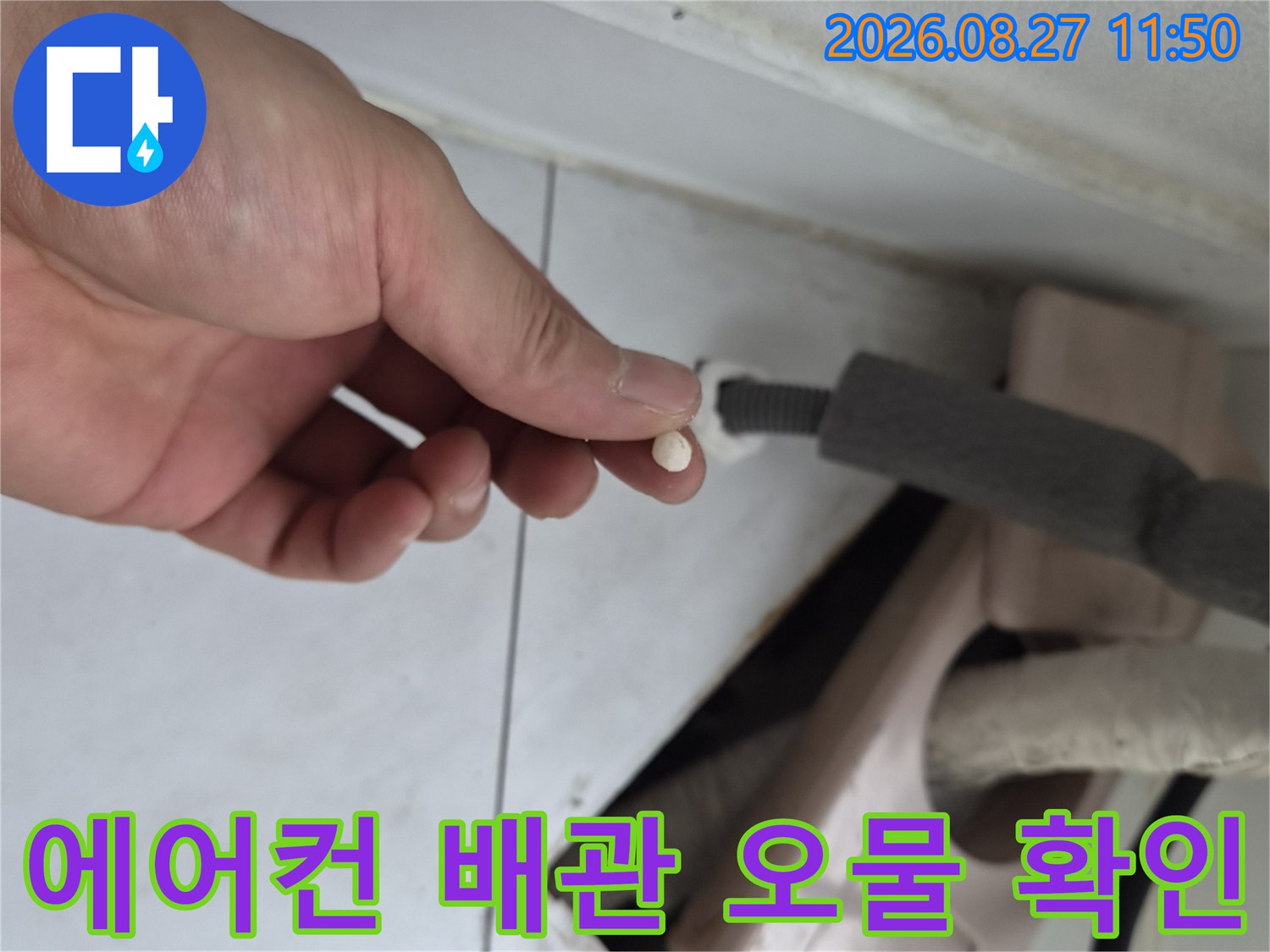 손가락 끝에 잡힌 에어컨 드레인 배관 내부 이물질