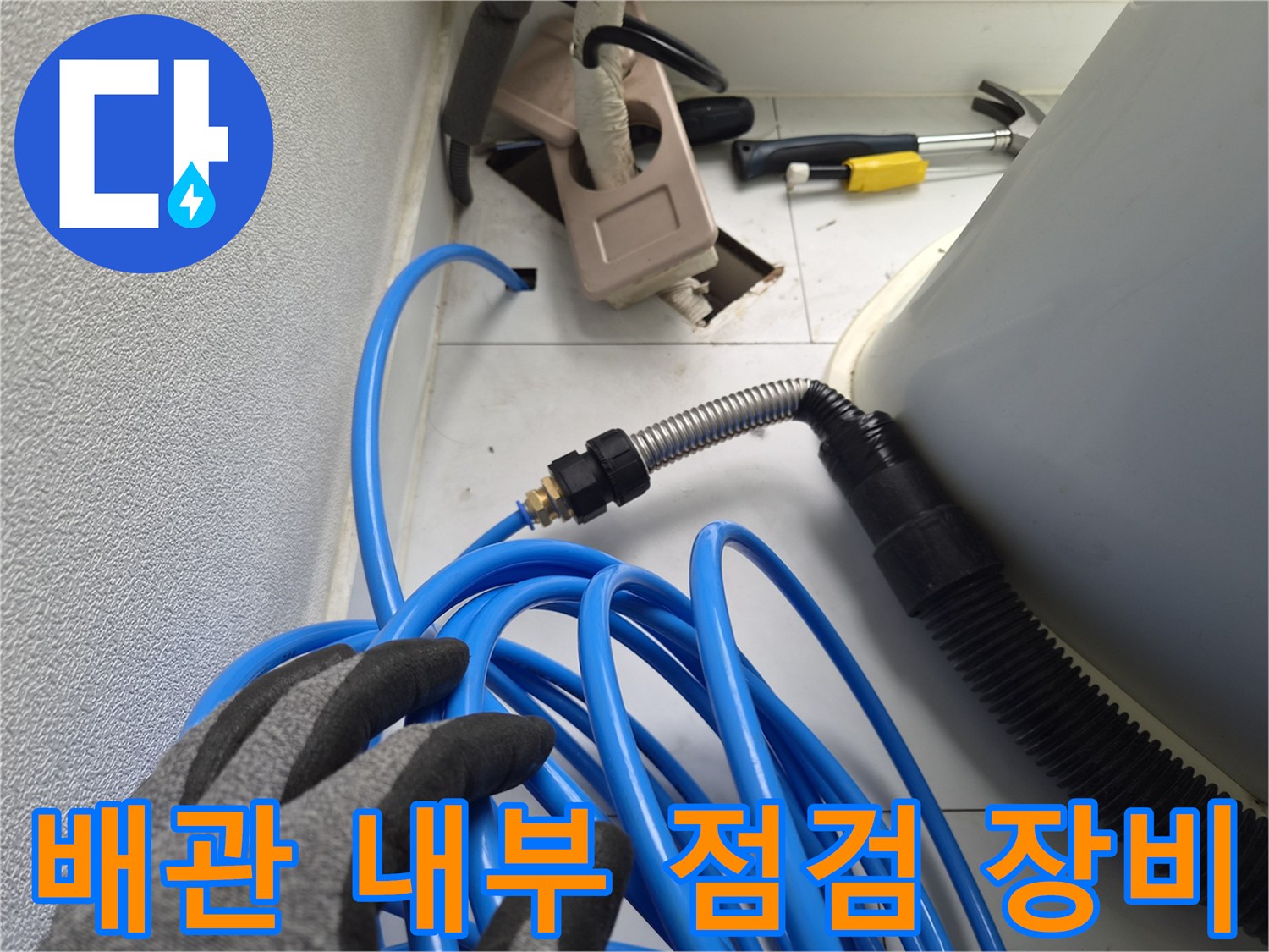 파란색 호스와 금속 자재가 연결된 배관 진단용 장치