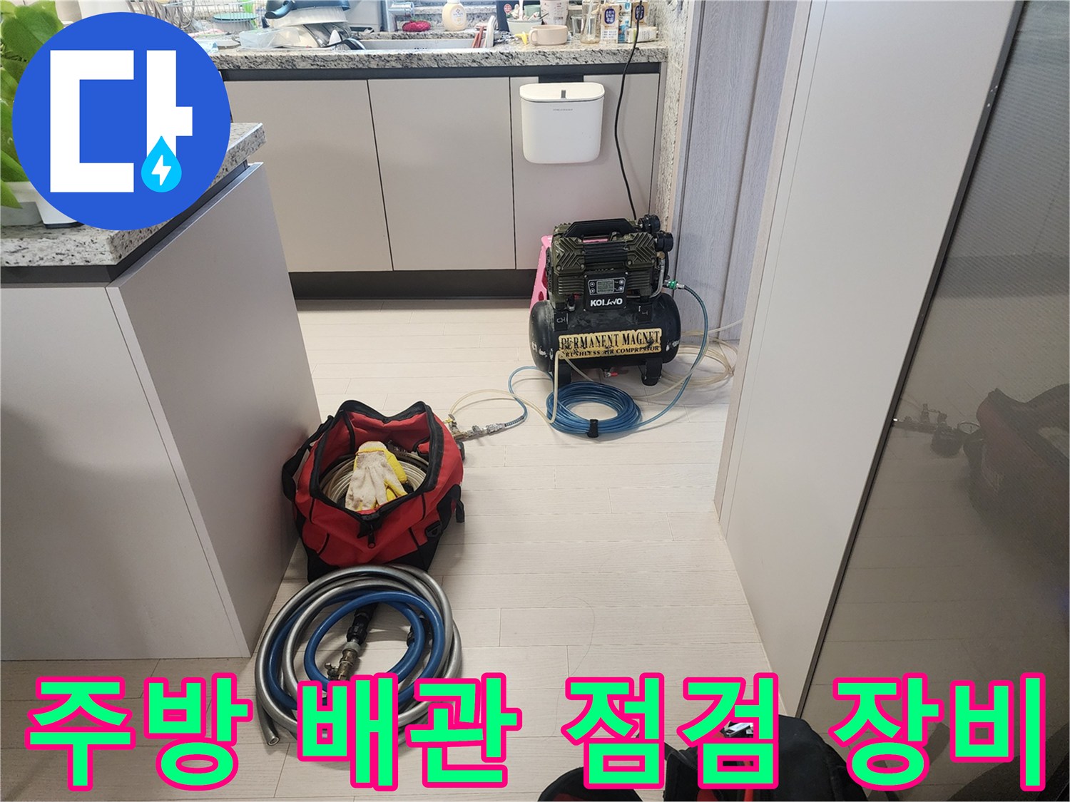 싱크대 하부장에 설치된 공압 테스트용 컴프레셔와 호스