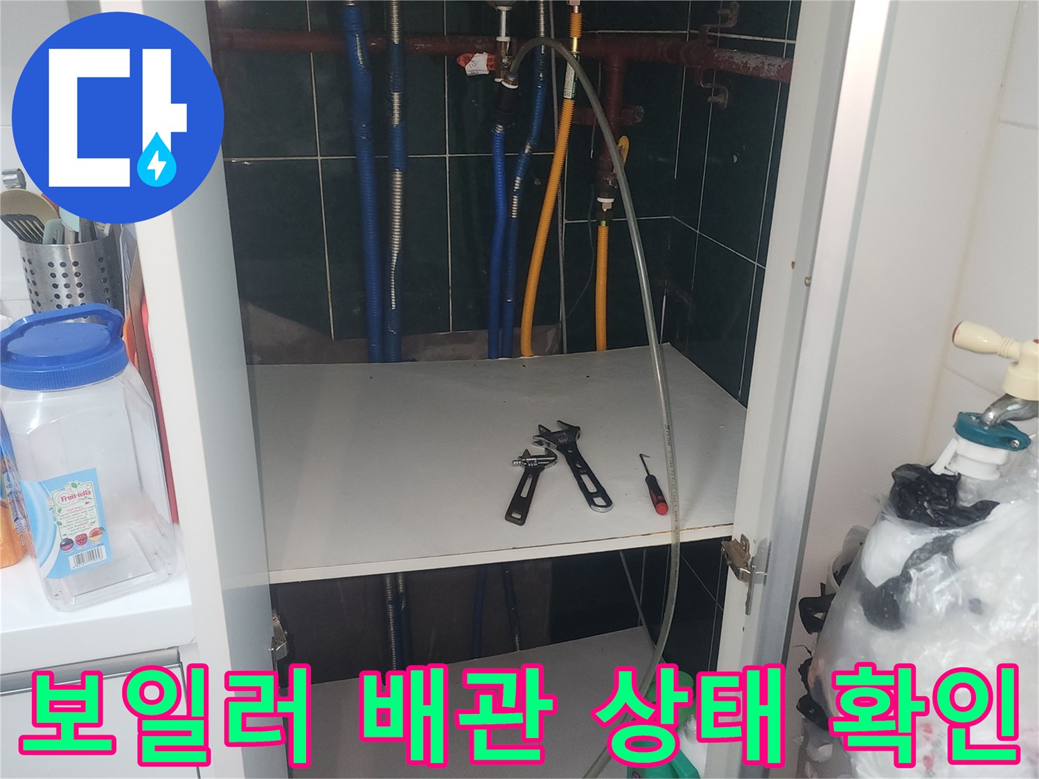 보일러실 내부의 노후된 분배기와 연결된 파란색 및 노란색 배관 모습