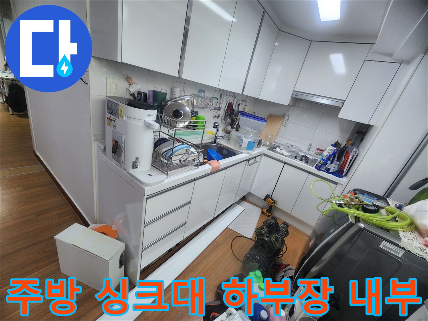 성북구 주방 싱크대 하부장 내부에 놓인 각종 살림살이와 배관 점검 공간