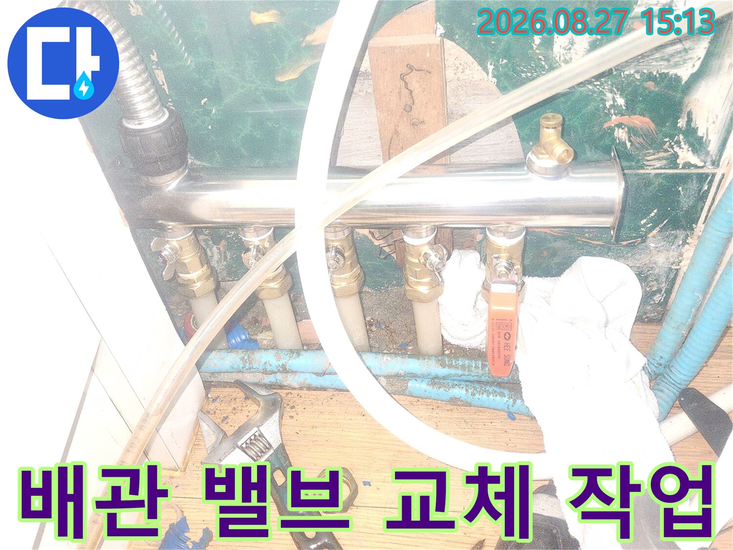 스패너를 사용하여 분배기 밸브 연결 부위를 조절하는 모습입니다.