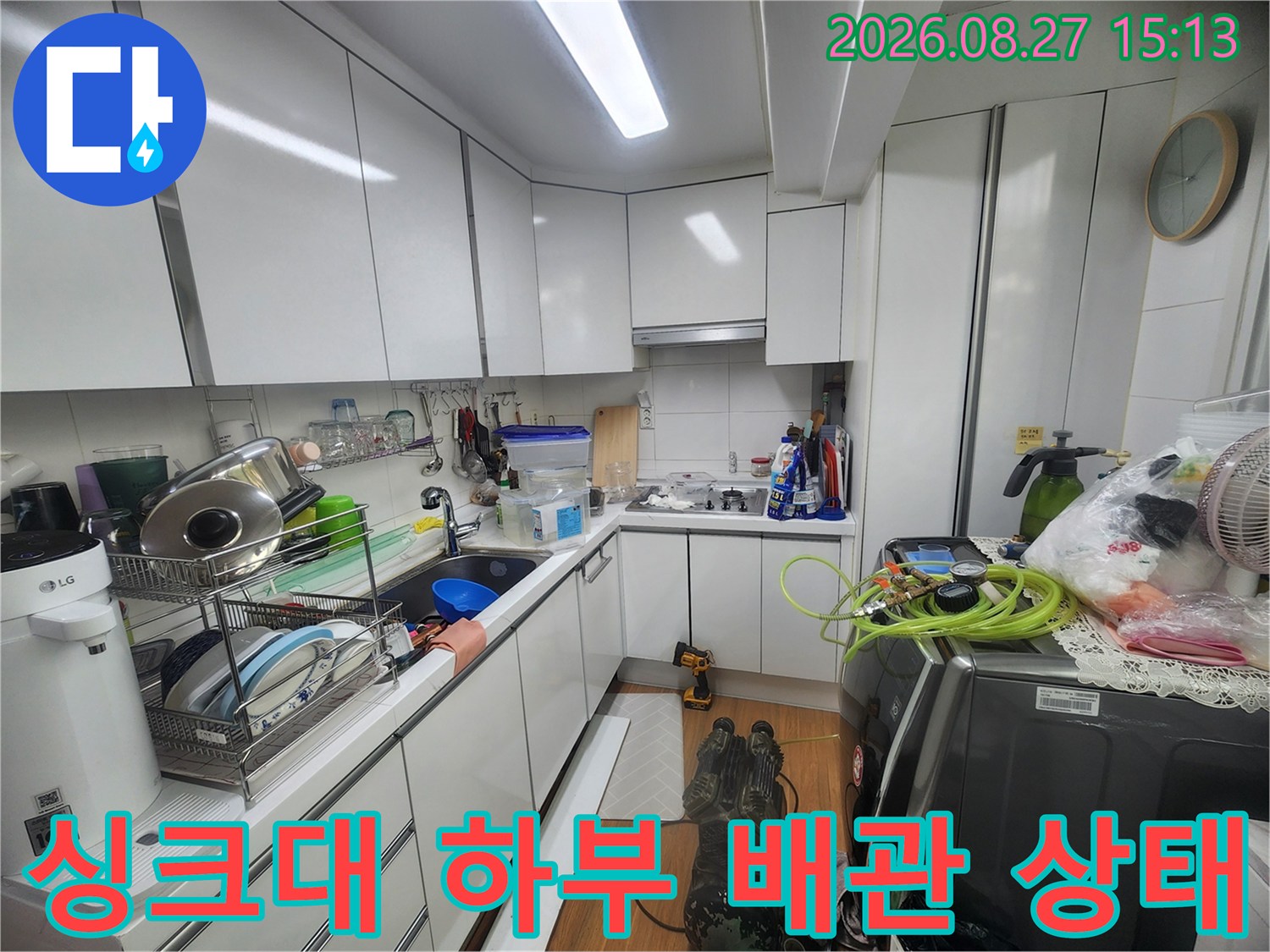 싱크대 하부장 내부의 정리된 모습과 배관 연결 부위