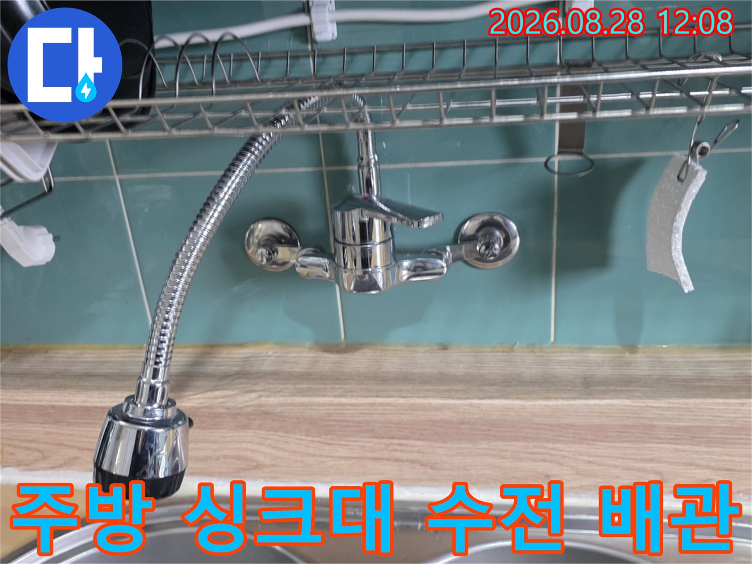 벽면 타일에 설치된 싱크대용 수도꼭지와 호스 모습