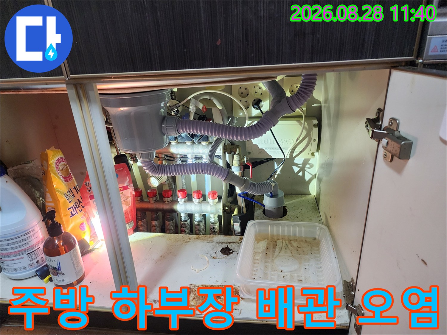 싱크대 밑바닥에 물기가 남아있고 배관 주변이 지저분한 누수 현장 상황
