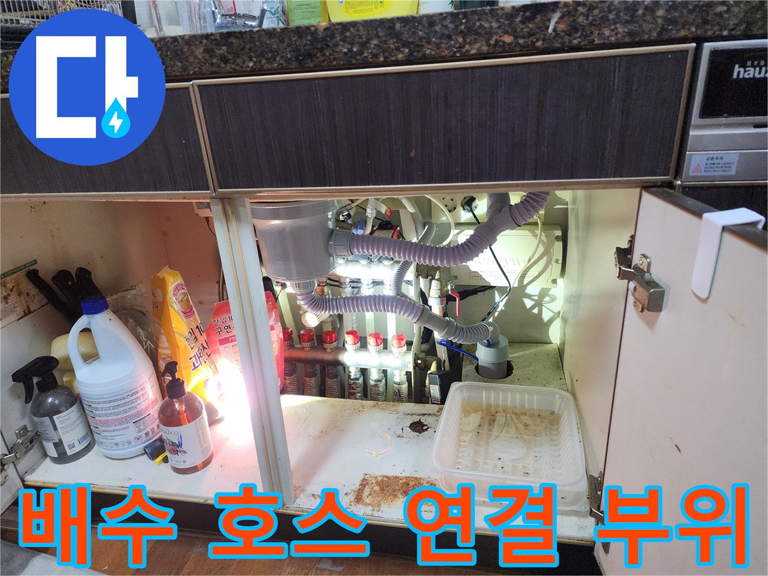 싱크대 하부 배관과 에어컨 드레인 호스의 연결 지점 상세 사진