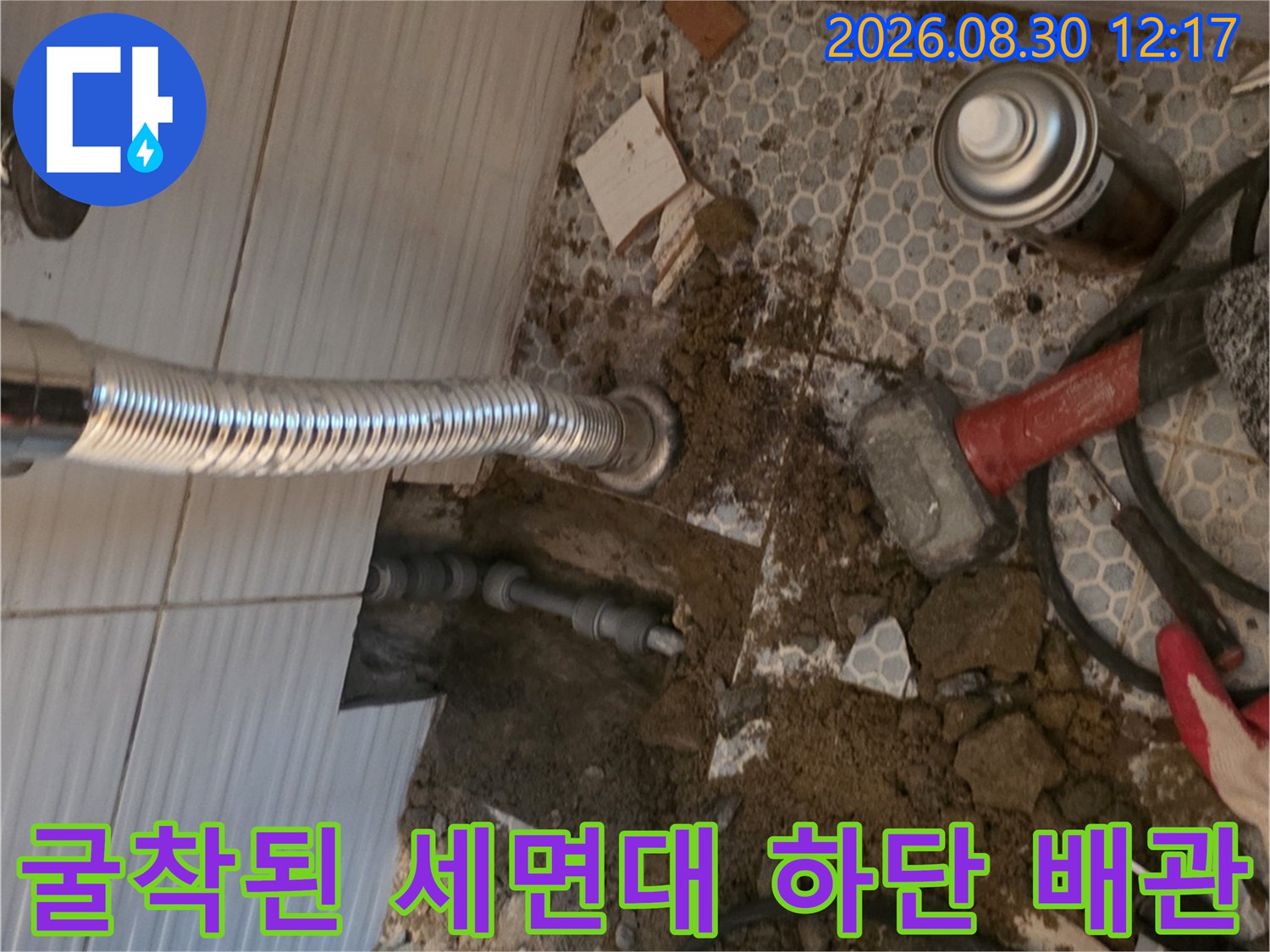 세면대 아래 타일을 깨서 드러난 매립 배관의 상태