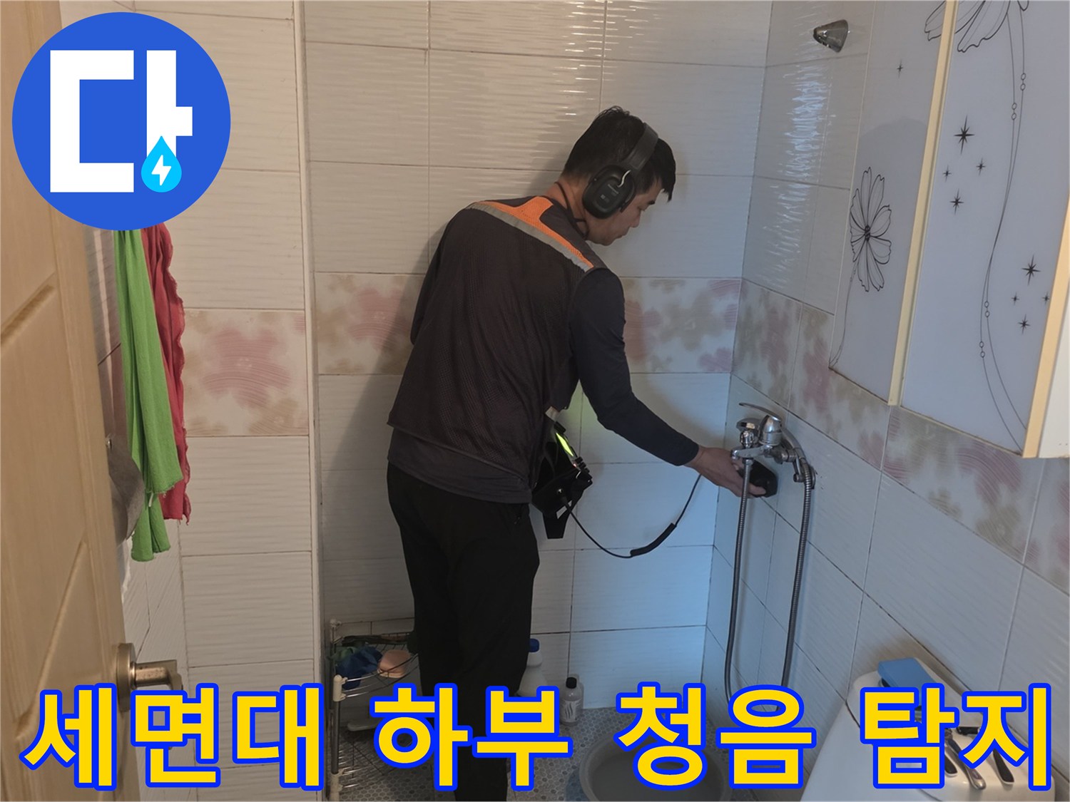 청음 장비를 착용하고 세면대 배관 연결부를 면밀히 조사하는 작업자