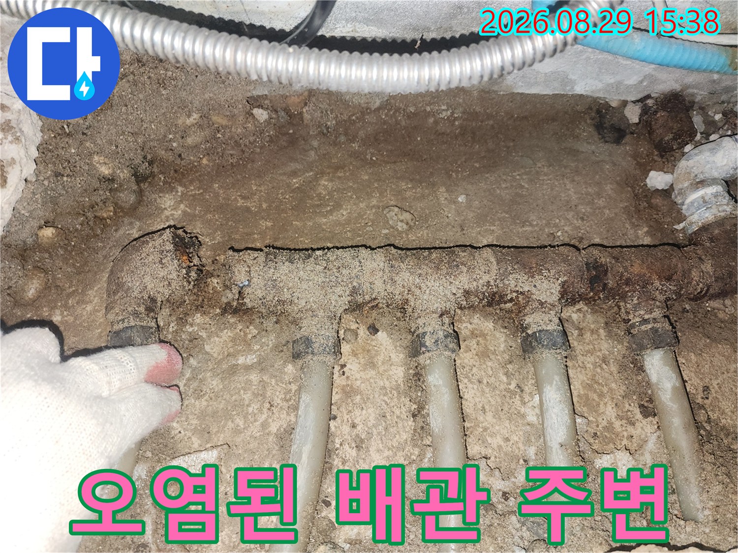 부식된 분배기 주변의 흙과 오염된 배관 모습입니다.