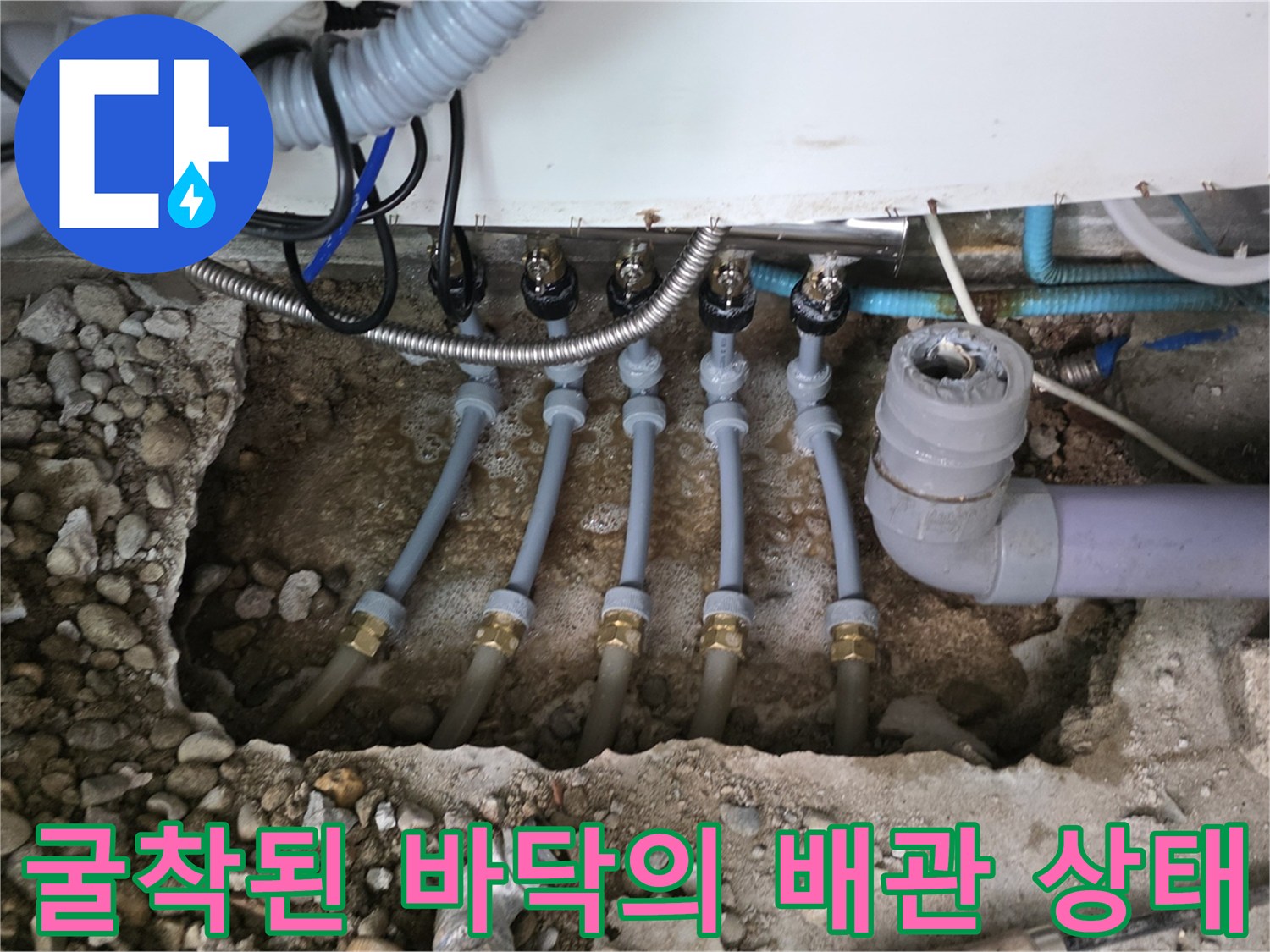 싱크대 아래 흙과 자갈 속에서 발견된 부식된 분배기 배관