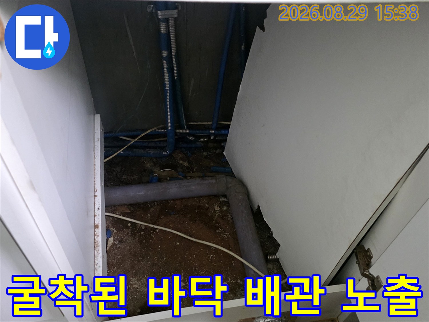 싱크대 하부 굴착 공간-드러난 파란색 수도 배관과 주변 토사