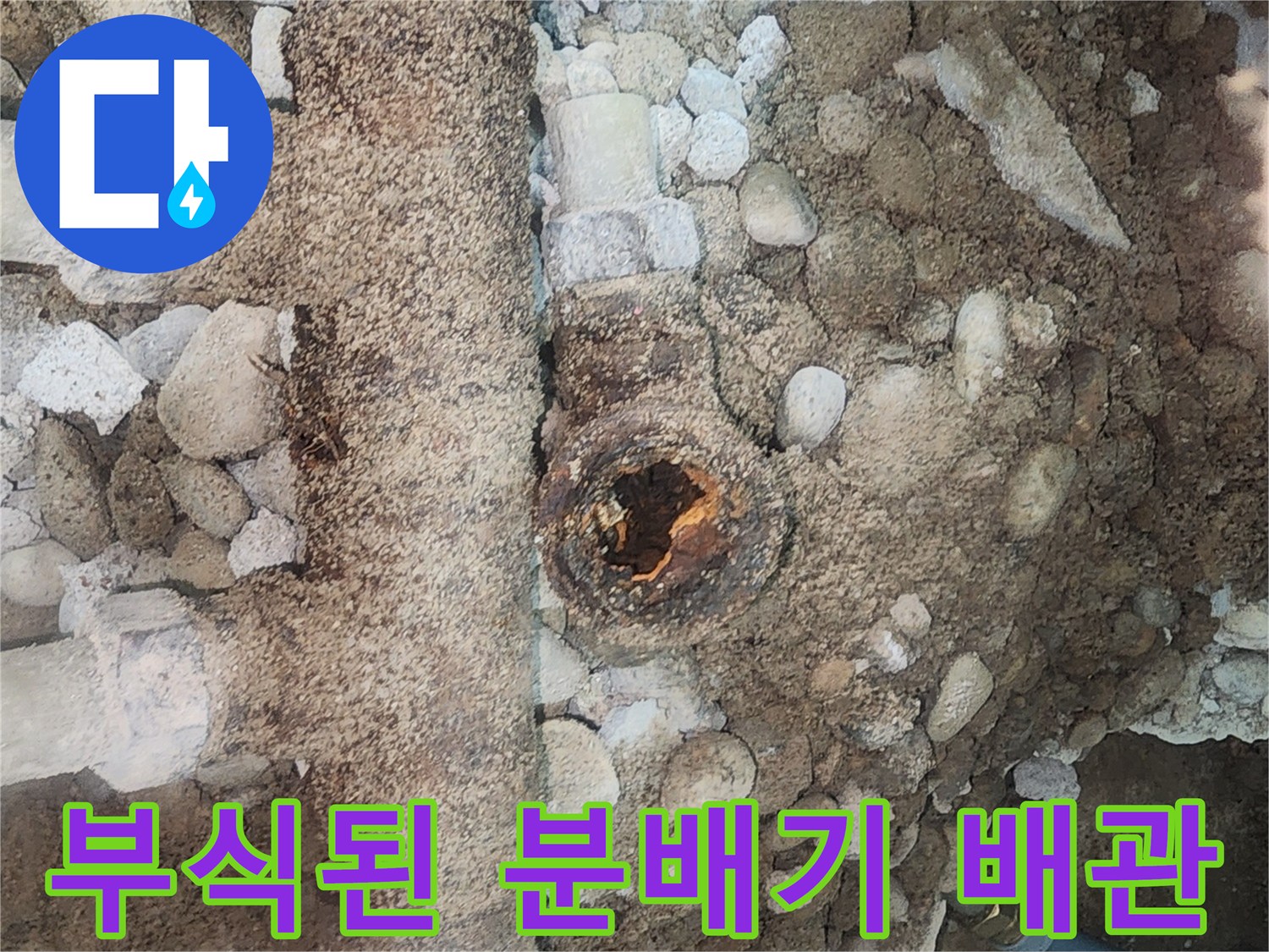 자갈과 흙 사이로 보이는 부식된 금속제 분배기 파손 부위