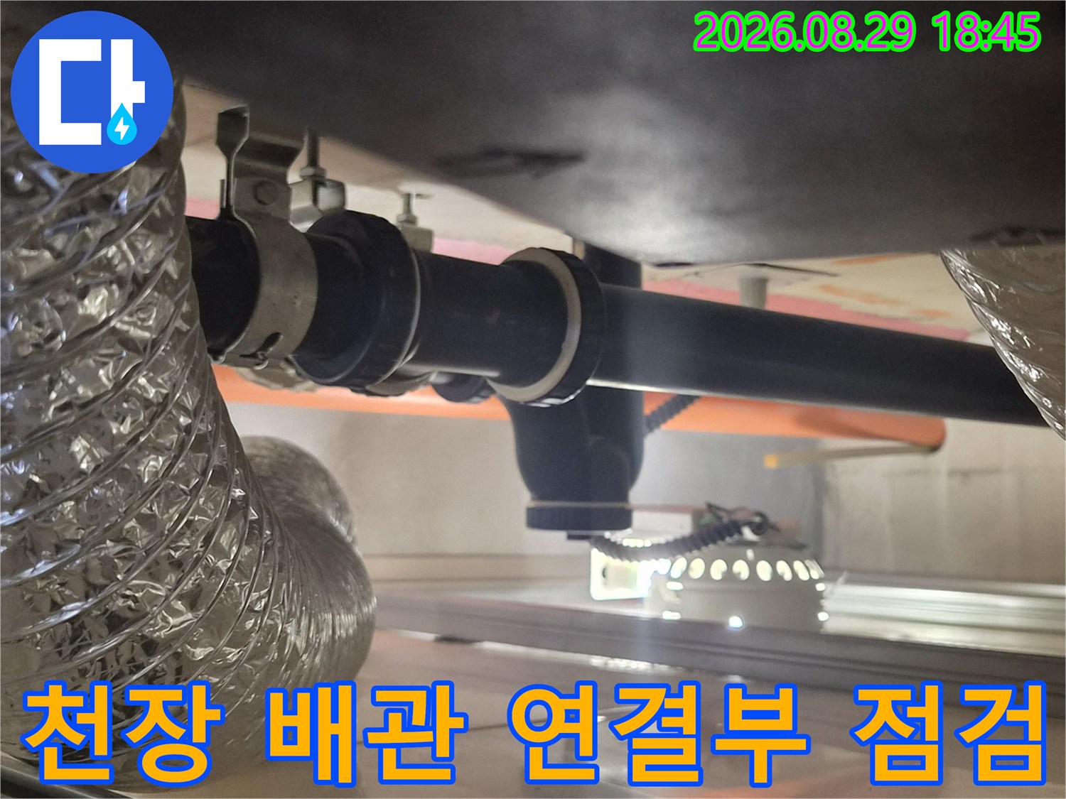 은색 보온재로 감싸진 배관과 검정색 하수도 배관의 연결 부위 근접 촬영