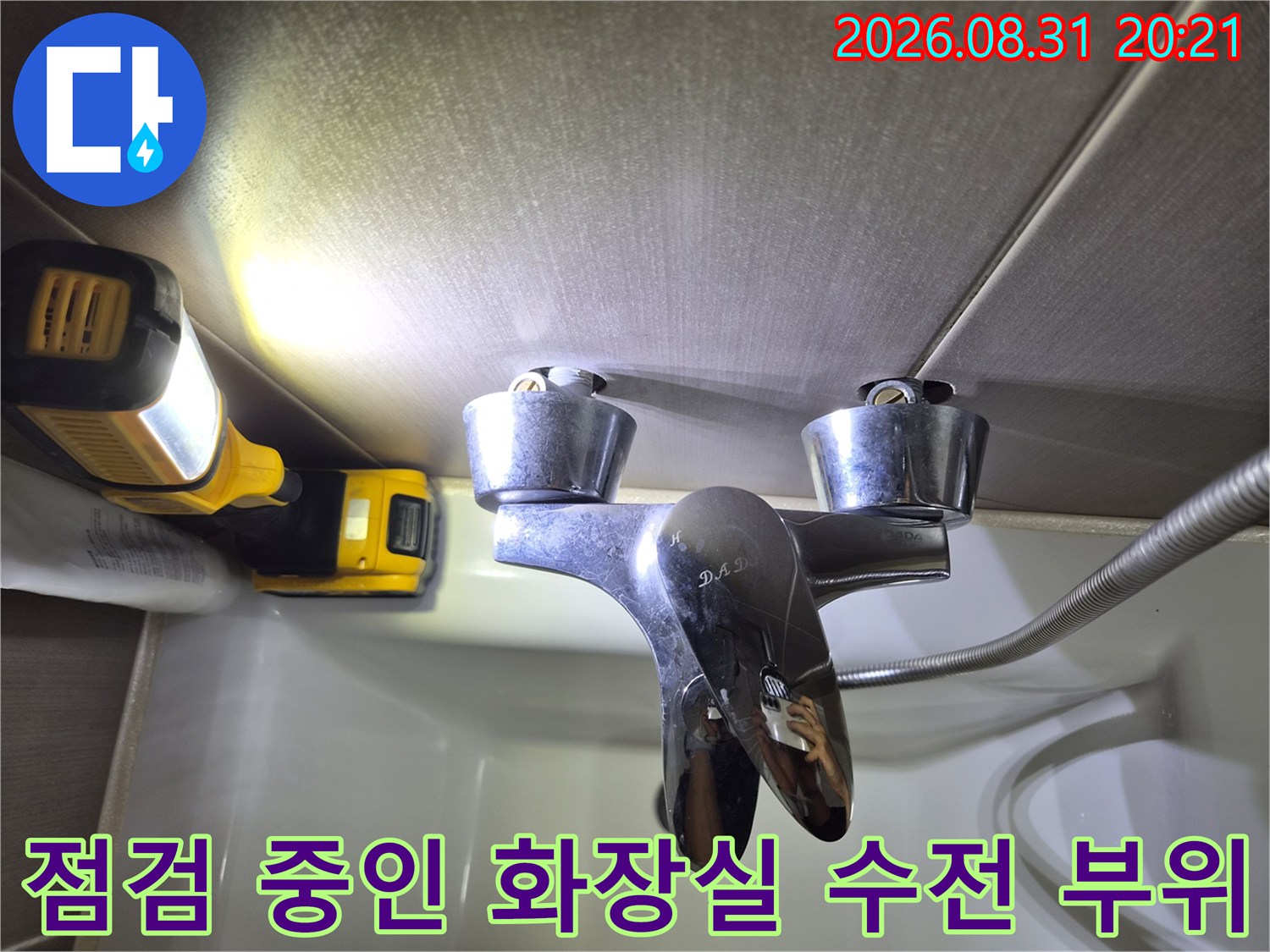 랜턴 조명으로 비춰진 은색 수전과 배관 연결부