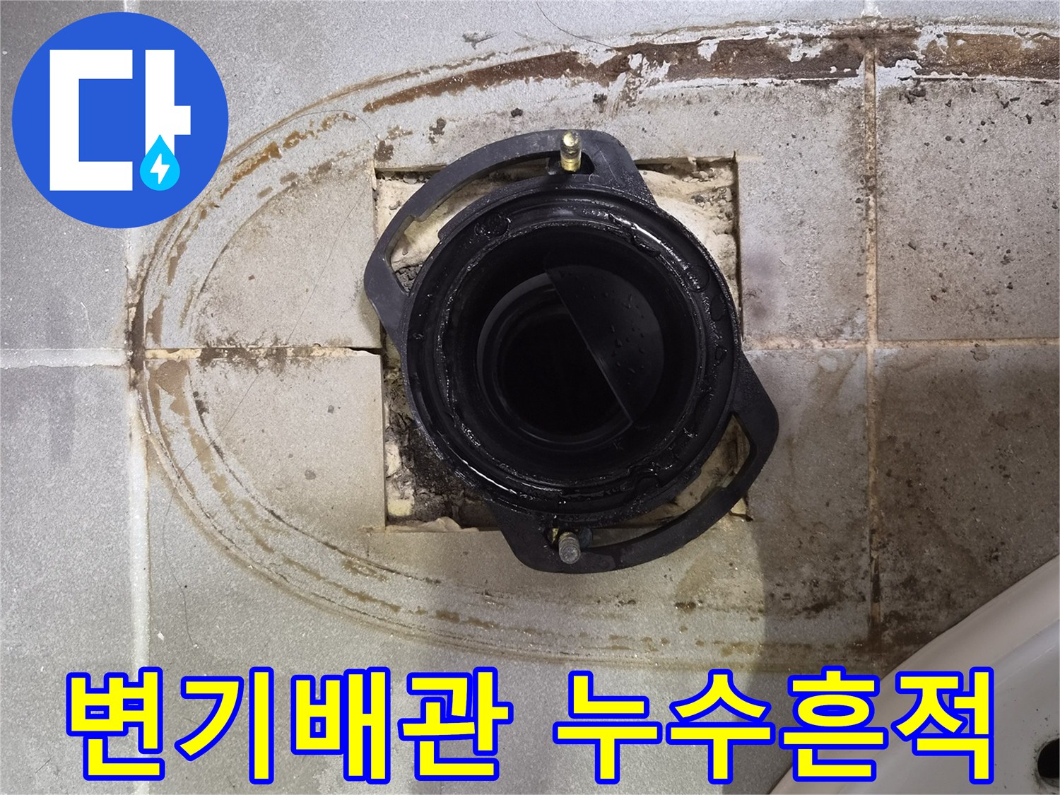 변기 배관 입구 주변의 젖은 타일과 오염된 흔적 사진