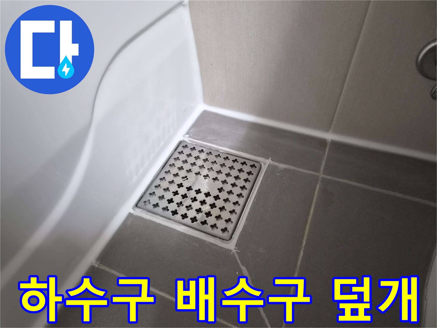 욕실 바닥의 금속제 배수구와 주변 타일 경계선