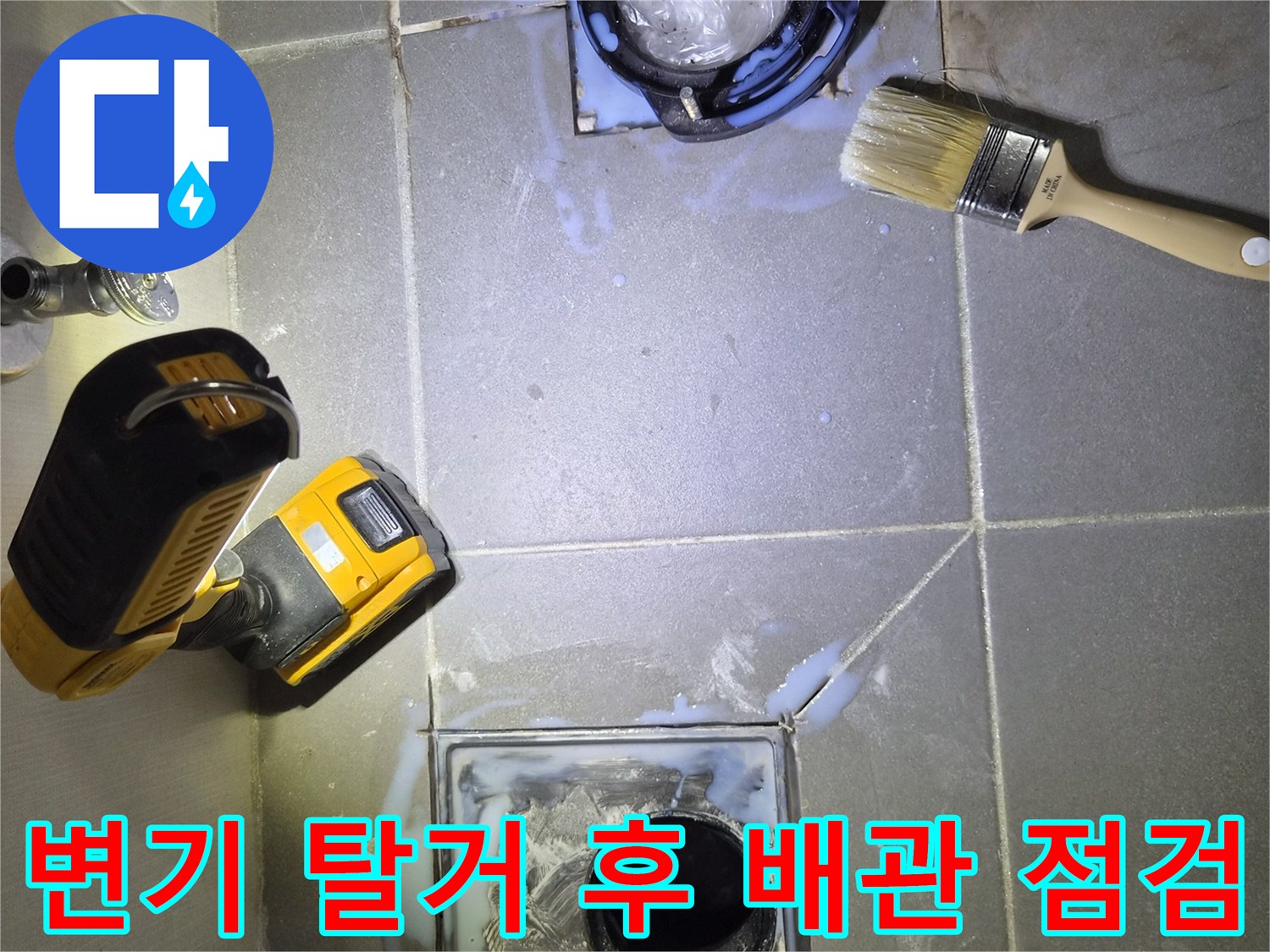 탈거된 변기 자리의 배수구와 작업용 전동드릴