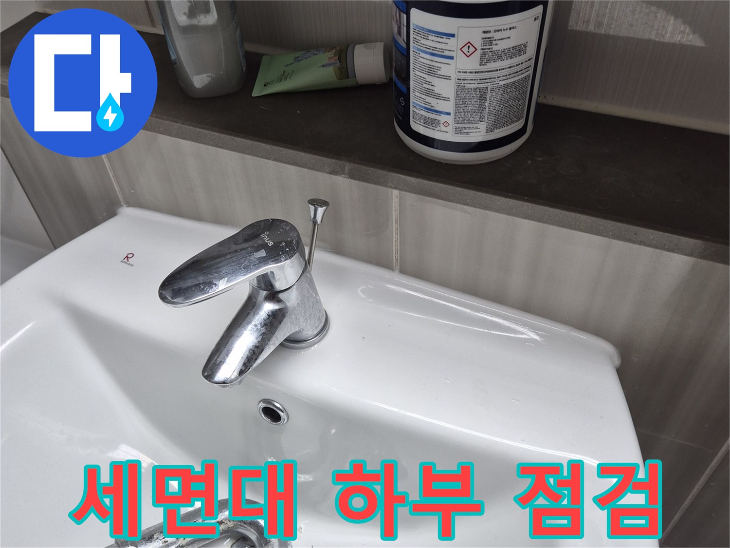 세면대 아래쪽 수전과 세정제 용기가 놓인 모습