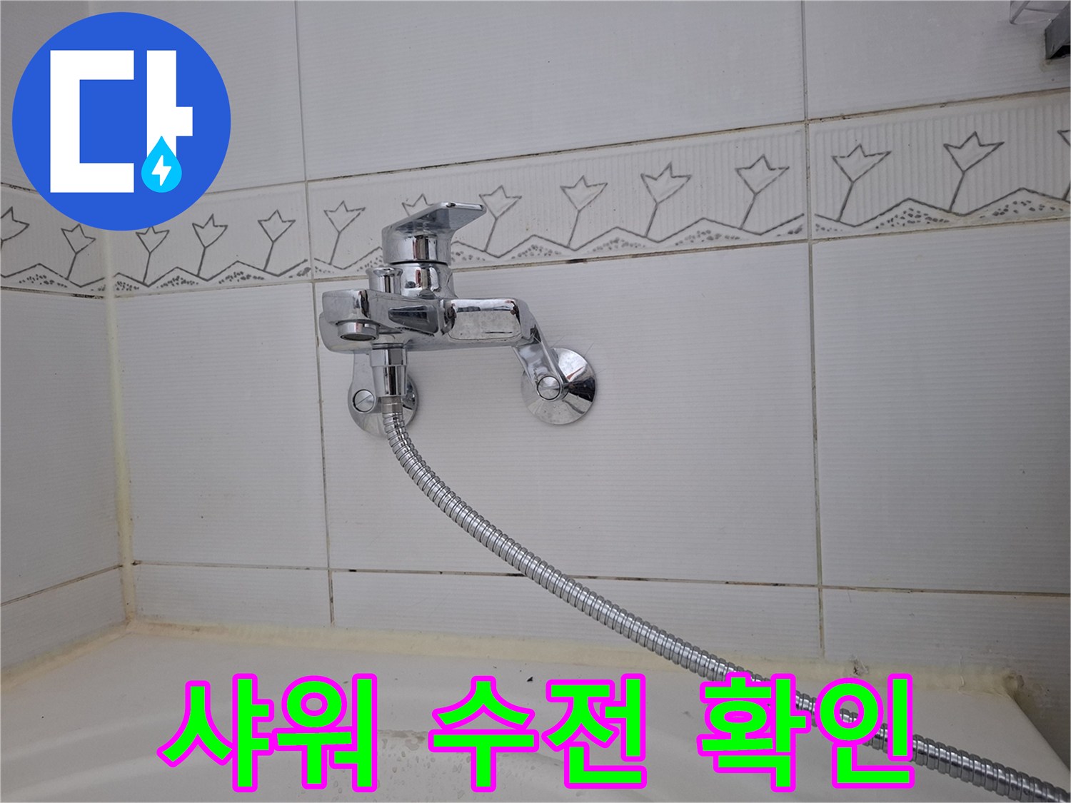욕조 위쪽 벽면 설치된 크롬 수전과 샤워기 호스